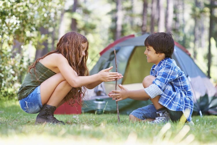 boy and girl playing in front of tent